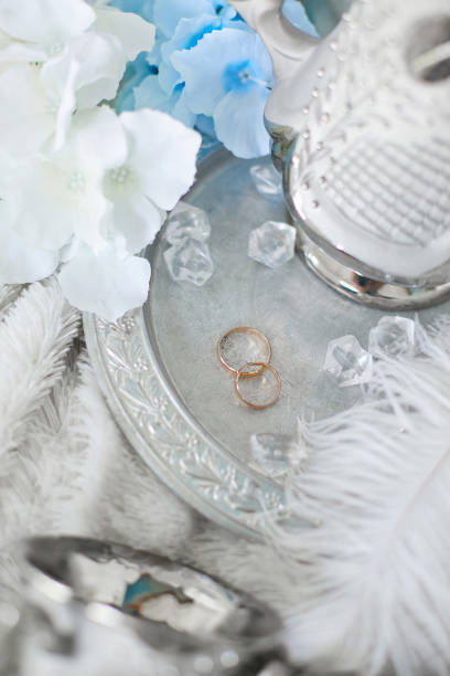 istock Gold wedding rings on a silver plate decorated with flowers 1221038675