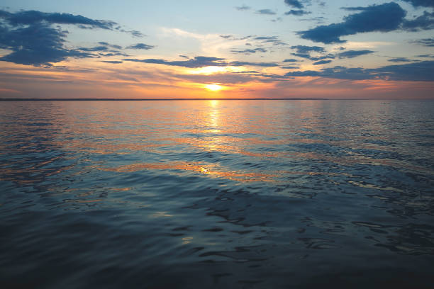istock Sunset on the sea. The sun is shining from behind the clouds. Small waves. 1221038735