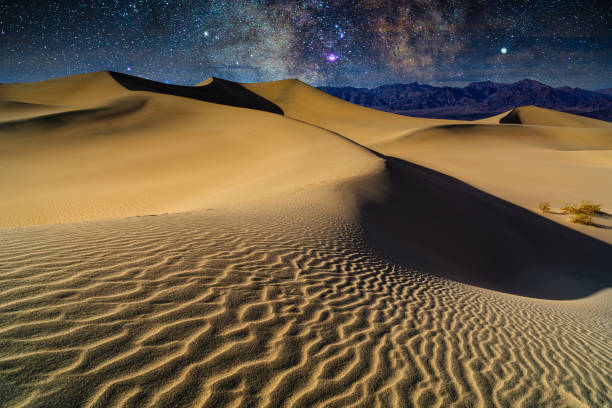 Sand Dunes Milky Way Galaxy in Death Valley Sand Dunes Milky Way Galaxy in Death Valley - Patterns on sand and scenic landscape views with night sky. Death Valley, California, USA. death valley desert photos stock pictures, royalty-free photos & images