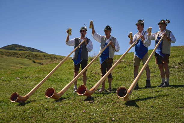 A group of alpine horn player performing outside a mountain hut. Seiser Alm, Italy - September, 2019. A group of alpine horn player performing outside a mountain hut. alpenhorn stock pictures, royalty-free photos & images