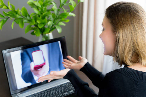 Online video call,marriage proposal to girlfriend.Laptop, computer.Engagement,wedding.Diamond ring in red box. Man:will you marry me.Surprised, shocked woman says yes. Quarantine,coronavirus covid-19