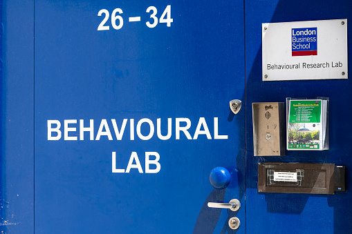 London, UK - June 24, 2018: Street road and University London Business School blue sign closeup and entrance to college Behavioural lab