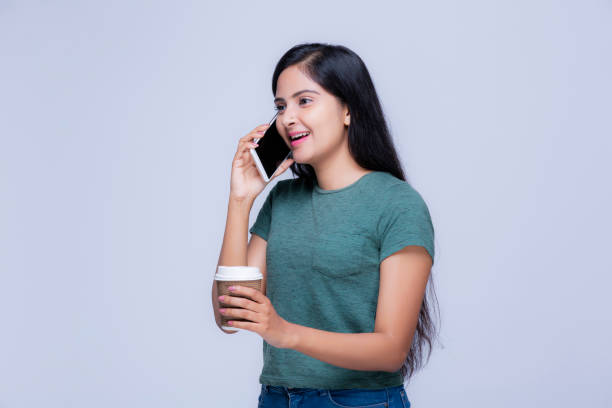 istock Girl with mobile phone at white background 1221041636