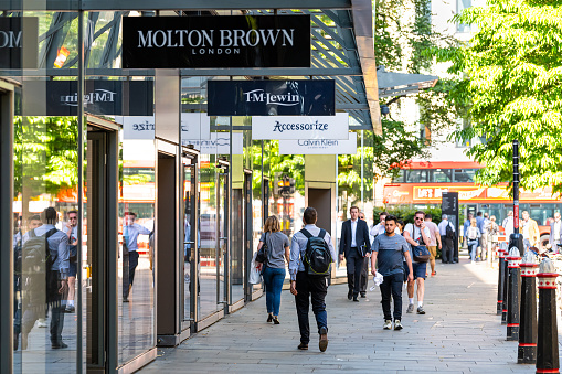 London, UK - June 26, 2018: People pedestrians walking on sidewalk street Cheapside road in center of downtown city by stores for Molton Brown and TM Lewin