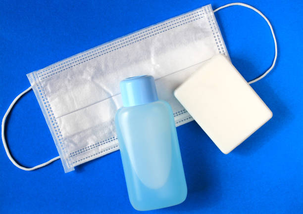 flat lay of soap, medical surgical mask and hand sanitizer on blue background. concept of prevention. - russian influenza epidemic virus flu virus imagens e fotografias de stock