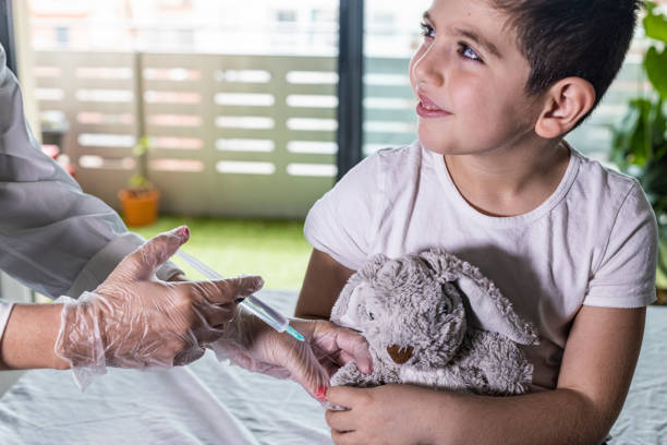istock Doctor vaccinating a little boy's teddy bear 1221046340