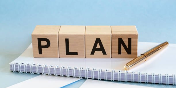 istock PLAN word on a wooden cubes on white notepad with golden pen 1221047928
