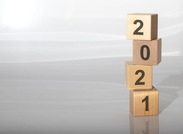 istock Four wooden cubes with number 2021 (new year) on white grey glossy background 1221047933