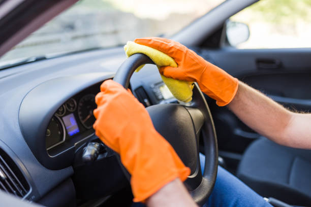 istock Man hands wearing rubber gloves and polishing steering wheel with microfiber cloth. 1221055413