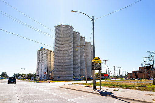 Larned, USA - October 14, 2019: Small town village city welcome sign in Kansas with downtown main street and industrial silo buildings on sunny day