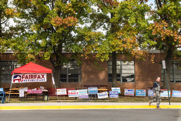 High school polling place station with road and Fairfax Republicans booth with people walking Herndon, USA - November 5, 2019: High school polling place station with road and Fairfax Republicans booth with people walking herndon virginia stock pictures, royalty-free photos & images