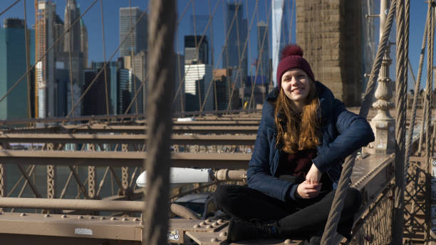 istock Beautiful girl on Brooklyn Bridge enjoys a sunny day while relaxing 1221057277
