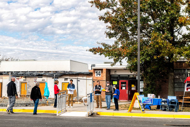 High school polling place with entrance and people handing out sample ballots and flyers Herndon, USA - November 5, 2019: High school polling place with entrance and people handing out sample ballots and flyers herndon virginia stock pictures, royalty-free photos & images