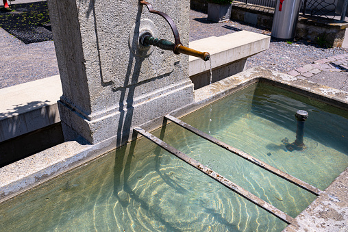A natural source of water flowing from a copper tap in the wall to the tank, very clean water.