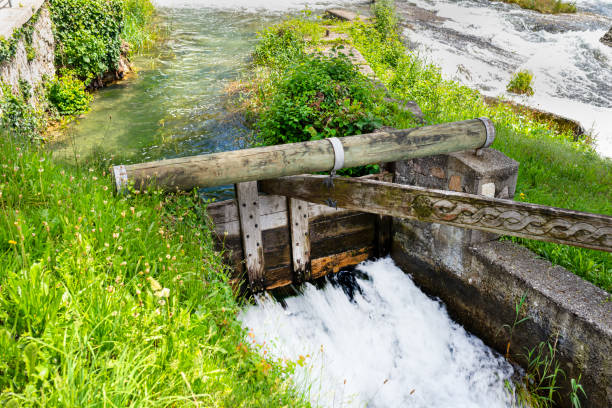A small dam on the river basin made of wood that requires manual operation.