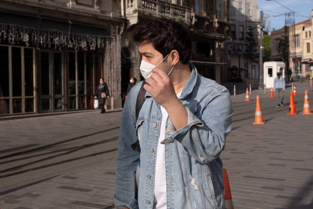 istock Young man is walking on the street with a protective mask 1221059811