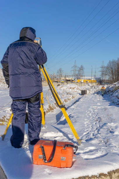 istock Surveyor with an assistant do a geodetic survey at a construction site 1221059942