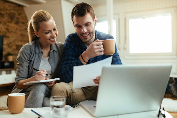 istock Happy couple making their home budget while going through finances together. 1221060016
