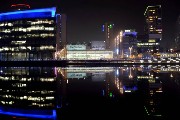 Salford Quays by night. SALFORD / UK - January 2019: Salford Quays at night. Media City is home to production studios of both the BBC and ITV as well as a variety of bars, restaurants and the Lowry Theatre. itv photos stock pictures, royalty-free photos & images
