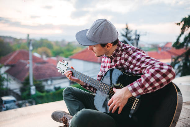 istock Young man playing the guitar at terrace 1221062511