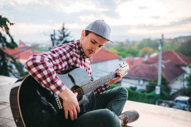 istock Young man playing the guitar at terrace 1221062512