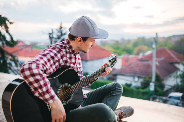 istock Young man playing the guitar at terrace 1221062514