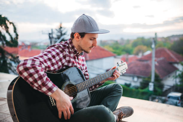 istock Young man playing the guitar at terrace 1221063275