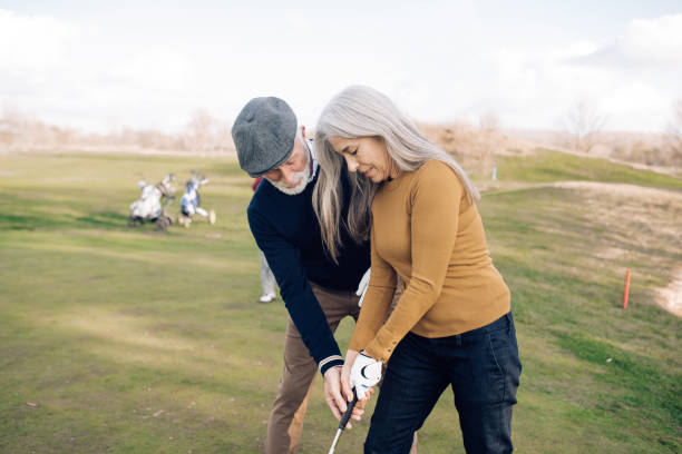 istock Senior man teaching his partner to play golf 1221063719
