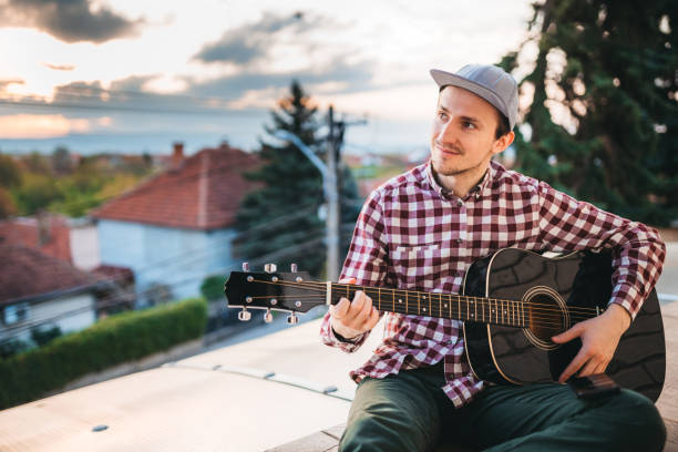 istock Young man playing the guitar at terrace 1221063804