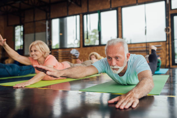istock Seniors doing back exercises on their group yoga class 1221063883