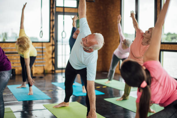 istock Group of seniors practicing yoga with their instructor 1221063906