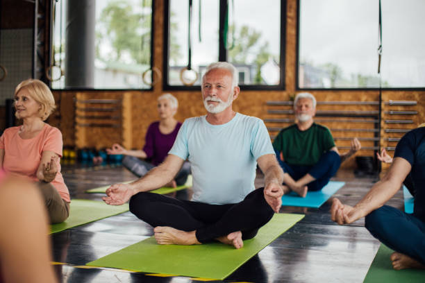 istock Seniors practicing meditation and mindfulness on a group yoga class 1221063911