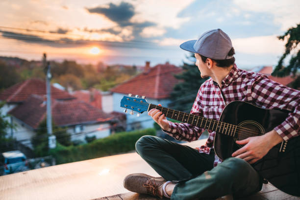istock Young man playing the guitar at terrace 1221064805