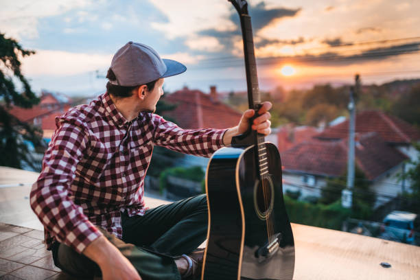 istock Playing guitar at sunset on the terrace 1221064808