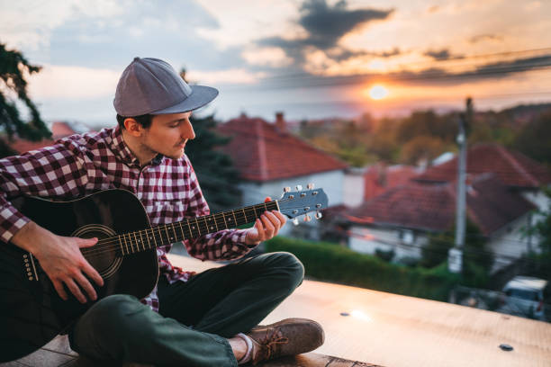 istock Young man playing the guitar at terrace 1221064844