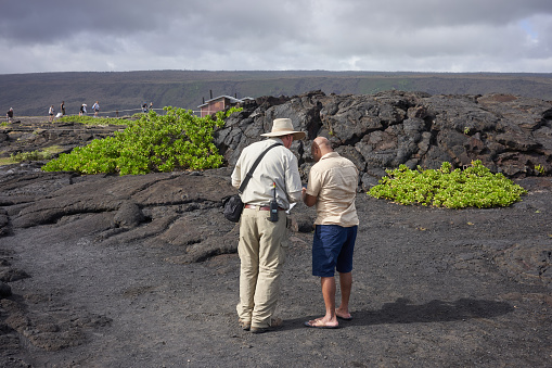 Hawaii Volcanoes National Park, HI, USA - Nov 26, 2019: A National Park Service park ranger gives advice to a visitor on where to visit in the Hawaii Volcanoes National Park.