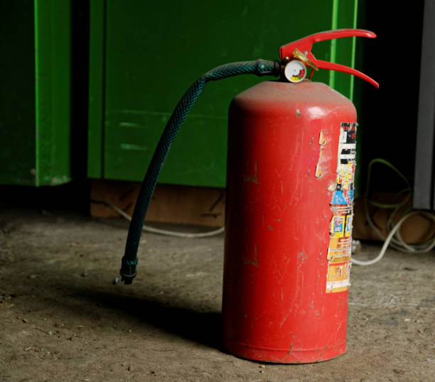 old fire extinguisher with dust cover isolated on white background