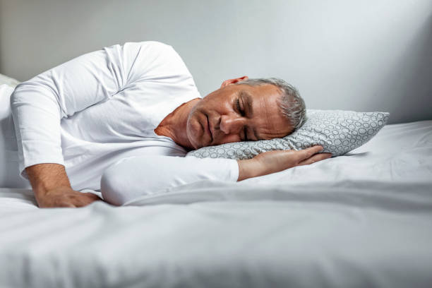 The simple pleasure of sleep Peacefulness concept. Handsome mature man sleeping in bed during the day. lying on side stock pictures, royalty-free photos & images