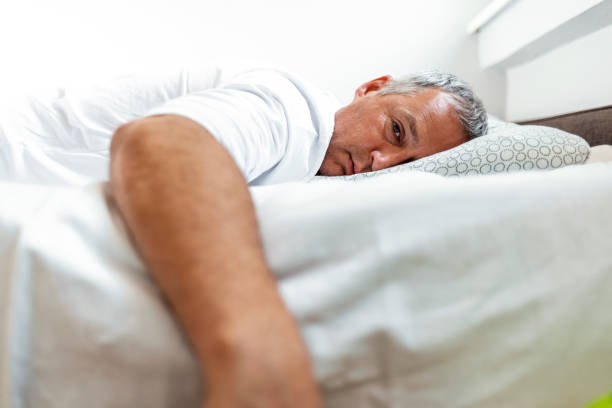 istock Depressed man lying in his bed and feeling bad 1221076827