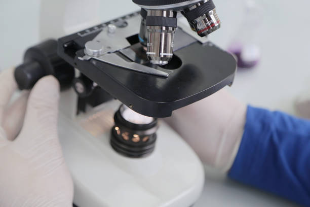 istock Young male male scientist looking through a microscope in a labo 1221079181