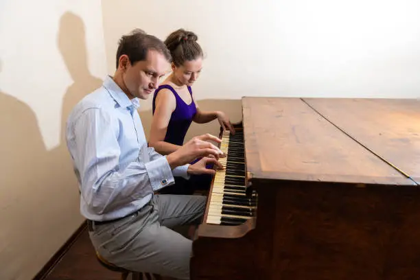 Forte piano room with young woman man romantic couple sitting pianist playing in formal dress in room for concert together