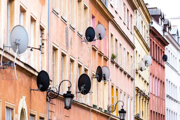 Many satellite dishes for internet and TV broadcasting signal in old town market square in Warsaw, Poland with colorful historic architecture apartment building