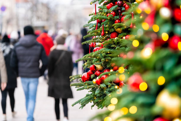 ワルシャワ、ポーランドの屋外で外の照明照明や装飾品からボケサークルと新年のクリスマスツリーのサイドビューと通りを歩く人々とポーランド - city street street walking tree ストックフォトと画像