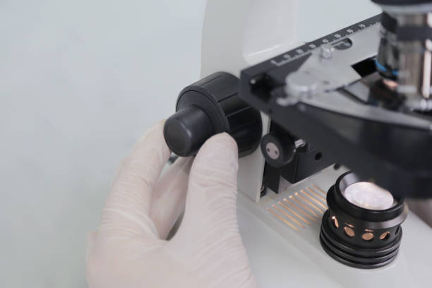 istock Young male male scientist looking through a microscope in a labo 1221082458