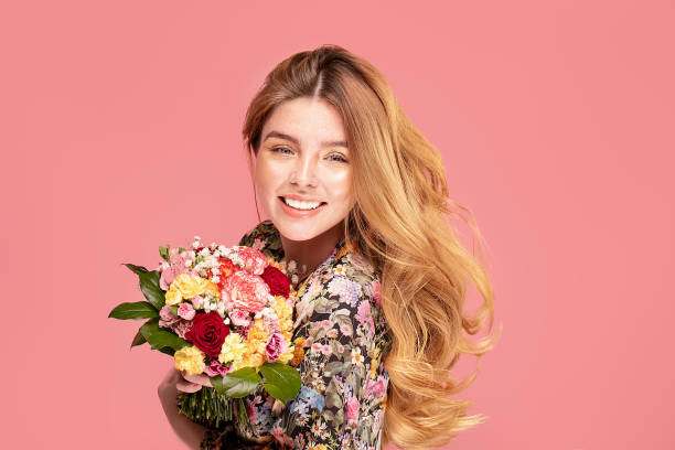istock Smiling woman with flowers in hand 1221083217