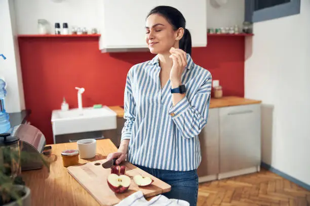 Vector illustration of Beautiful fit woman eating fruit at home