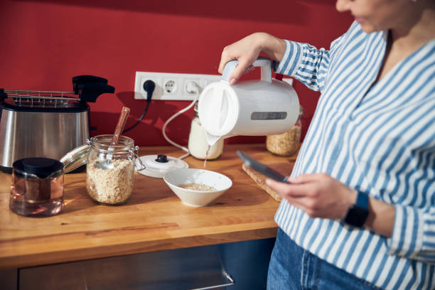 istock Caucasian woman pouring hot water from kettle in kitchen 1221089830