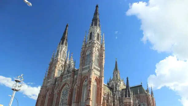 Facade of the majestic La Plata Cathedral (Neo-Gothic architectural style), with some clouds in the blue sky, Argentina