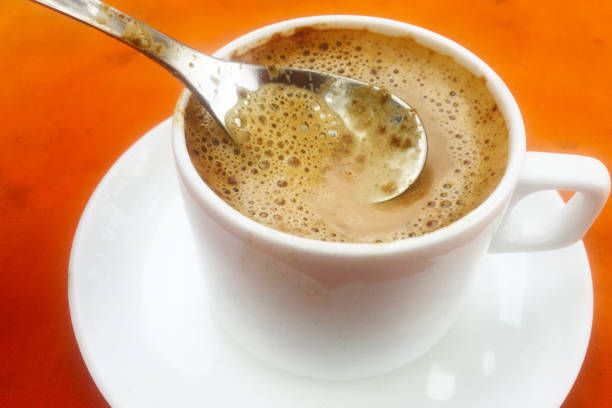 Milk coffee  with foam on the orange table