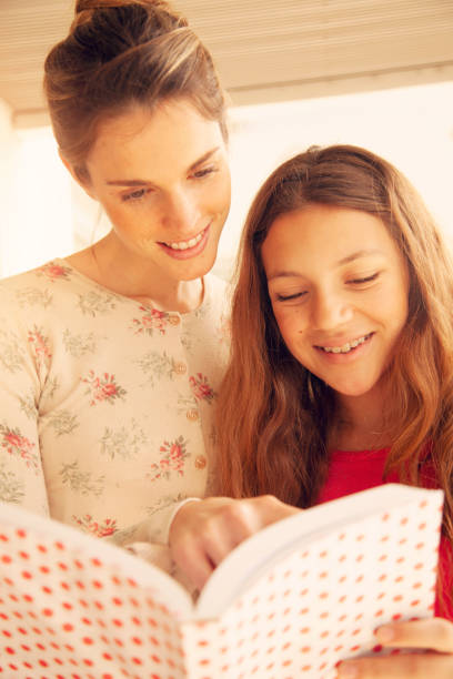 istock Mother and daughter reading book at home 1221097196